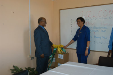 Governor General, His Excellency the Most Hon. Professor Kenneth Hall, hands over boxes of foodstuff along with cleaning and disinfecting products to Director of Nursing Services at the Noel Holmes Hospital in Lucea, Denise Malcolm. The presentation, which is on behalf of Lascelles Chin, Chairman and Chief Executive Officer of Lasco Group of Companies, was made at the hospital.