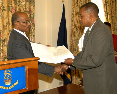 Governor General, His Excellency, the Most Hon. Professor Sir Kenneth Hall, (left) presents a copy of the Proclamation declaring November as Drug Awareness Month, which he read during a brief ceremony at King's House on October 31, to Executive Director of the National Council on Drug Abuse, (NCDA) Michael Tucker.