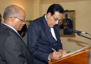 Governor General, His Excellency the Most Hon. Professor Sir Kenneth Hall (left), looks on as Justice Mahadev Dukharan, Judge of the Court of Appeal, signs document to confirm his status, at King's House on October 29. The Governor General presented three judges with their instruments of appointment to higher offices in the judiciary, during the ceremony.