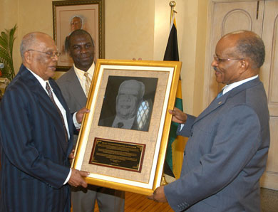 Governor-General, His Excellency the Most Hon. Professor Sir Kenneth Hall (right), presents the Jamaica Agricultural Society's (JAS) Gold Medal Award to his predecessor, the Most Hon. Sir Howard Cooke (left), at a ceremony, held at King's House on December 5. The award was presented to the former Governor-General in recognition of his outstanding contribution to nation building, particularly, in agriculture and the development of the JAS. At centre is JAS President, Senator Norman Grant.