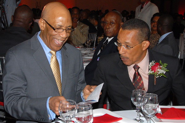 Governor-General, His Excellency the Most Hon. Dr. Patrick Allen (left), seems very amused at a comment made by President and Chief Executive Officer (CEO), Guardian Life Limited, Earl Moore, at the organisation's annual awards ceremony, held at the Jamaica Pegasus Hotel, in Kingston, on March 3. The Governor-General was the guest speaker at the function.