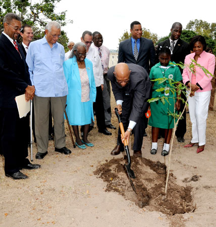 Governor-General, His Excellency the Most. Hon. Dr. Patrick Allen (centre), shovels dirt as he plants a Pious tree on the lawns of King's House, to launch the Jamaica Tree Growers Association's National Tree Growing programme, on April 22. Looking on (from left) are: Secretary, Jamaica Tree Growers Association, Guy Symes; Custos of Kingston, the Very Reverend Canon Weeville Gordon; Custos of St. Andrew, Bishop The Hon. Dr. Carmen Stewart; Student of St. Martin Primary School, Avrian Harris, and wife of the Governor- General, Her Excellency the Most Hon. Mrs. Allen.