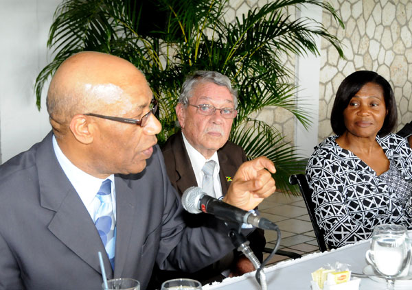 Governor General, His Excellency the Most Hon.  Dr. Patrick Allen (left), addresses the audience at the Governor General’s Achievement Awards youth consultative breakfast for the county of Middlesex held on May 15 at the Caymanas Golf and Country Club in St. Catherine.  Listening intently are Custos for  Clarendon, James deRoux (centre) and the Governor General’s wife, Patricia Allen.