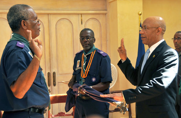 Governor-General, His Excellency the Most Hon. Sir Patrick Allen (right), says the scout's promise, as directed by Chief Commissioner of the Scout Association of Jamaica, Rev. Barrington Soares (left), during a ceremony at King's House, today (September 4), to invest the Governor-General as Chief Scout of Jamaica. Also participating is the Association's Field Commissioner, Delroy Davis.