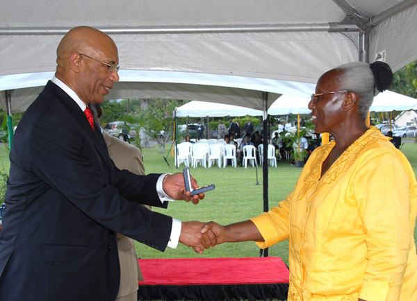 Governor-General, His Excellency the Most Hon. Sir Patrick Allen (left), presents Family Nurse Practitioner at the Gayle Health Centre in St. Mary, Miss Patsy Jennifer Tracey, with her award for long service, during a ceremony held on the lawns of King's House on Wednesday (November 19). Miss Tracey, who was one of more than 670 civil servants awarded, was the recipient with the most years of service, having served 39 years.