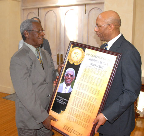 The Governor-General, His Excellency the Most Hon. Sir Patrick Allen (right), presenting outgoing Custos Rotulorum of Trelawny, the Hon. Roylan Barrett, with a citation in recognition of his18 years of service in that capacity, during an appreciation luncheon at King's House on Monday (December 7). The luncheon also honoured fellow Custodes, the Rev. Canon. Weeville Gordon, Kingston, and the Hon. Clarence Nelson, St. James, who have or will demit office this year.