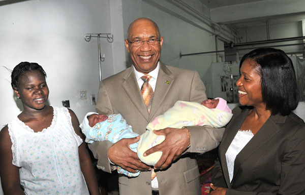 Governor-General, His Excellency the Most Hon. Sir Patrick Allen (centre), holds newborn twins, Jadeen Grey and Jazzmine Grey, in his arms, when he visited the Victoria Jubilee Hospital, in Kingston, today (December 22), as part of his Christmas visits to hospitals. At right is Lady Allen, while at left is the mother of the babies, Ms. Jodi McKenzie.