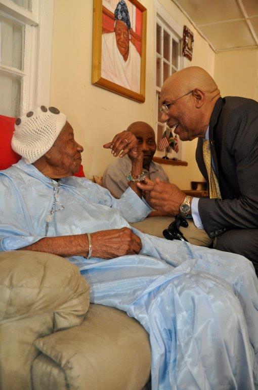 Governor-General Sir Patrick Allen share a ligh moment with Ms. Vioris Brown, the world's second oldest person alive at her Duanvale home in Trelwany on March 9, 2017. looking on is her son Mr. Fairweather.