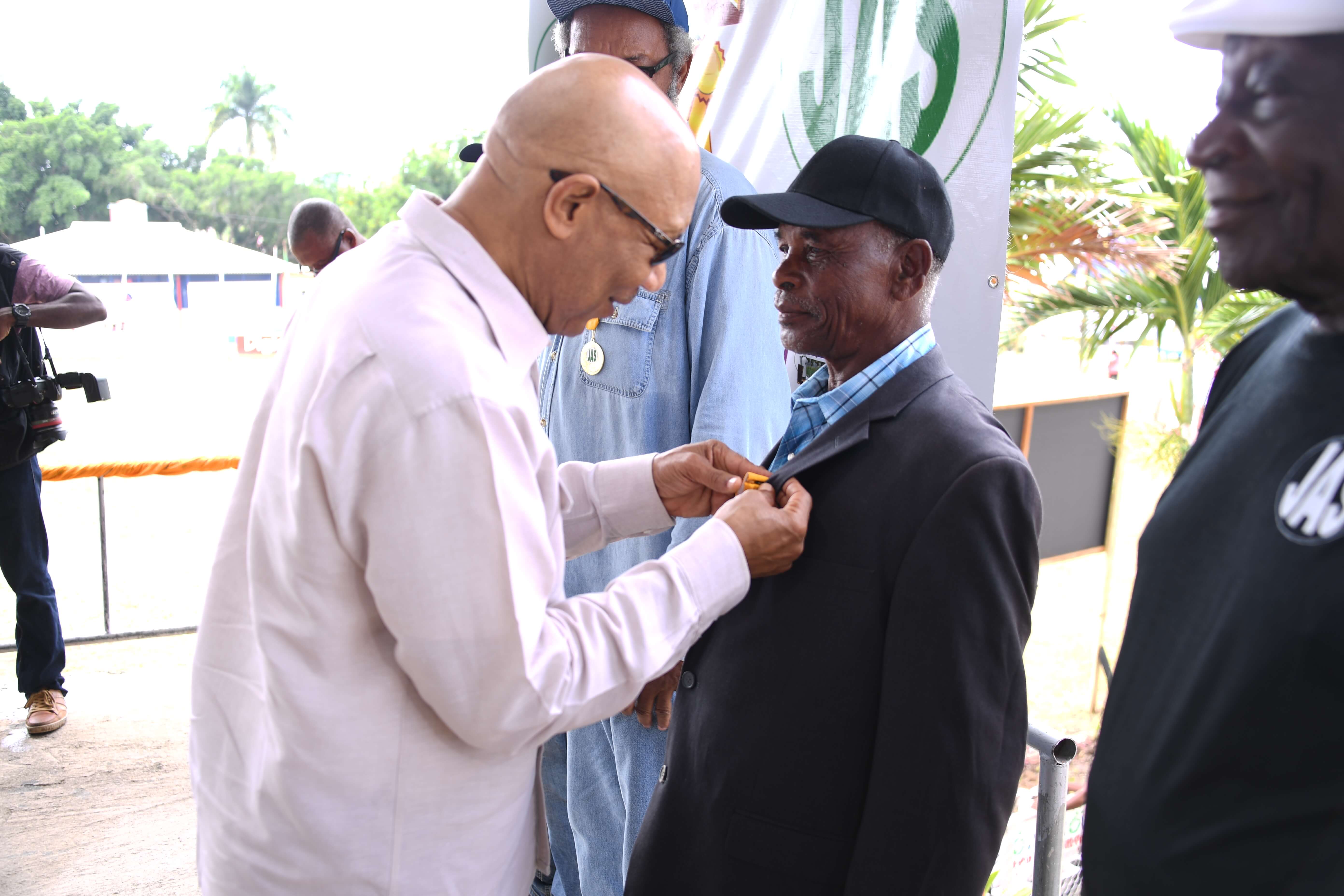 His Excellency the Most Honourable Sir Patrick Allen pins one of the 65 farmers bestowed with a medals of appreciation for their outstanding contribution to the agricultural sector during. The occasion was the 65th staging of Denbigh Agricultural, Industrial and Food Show in Clarendon on Sunday (August 6, 2017).