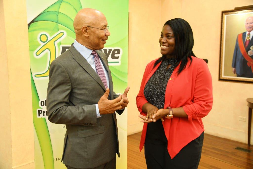 Sir Patrick Allen interacts with Dr. Angelica Baker, a scholarship recipient of the inaugural I Believe Initiative Summer Of Service Competition in 2013 during the awards ceremony yesterday (August 22, 2017).