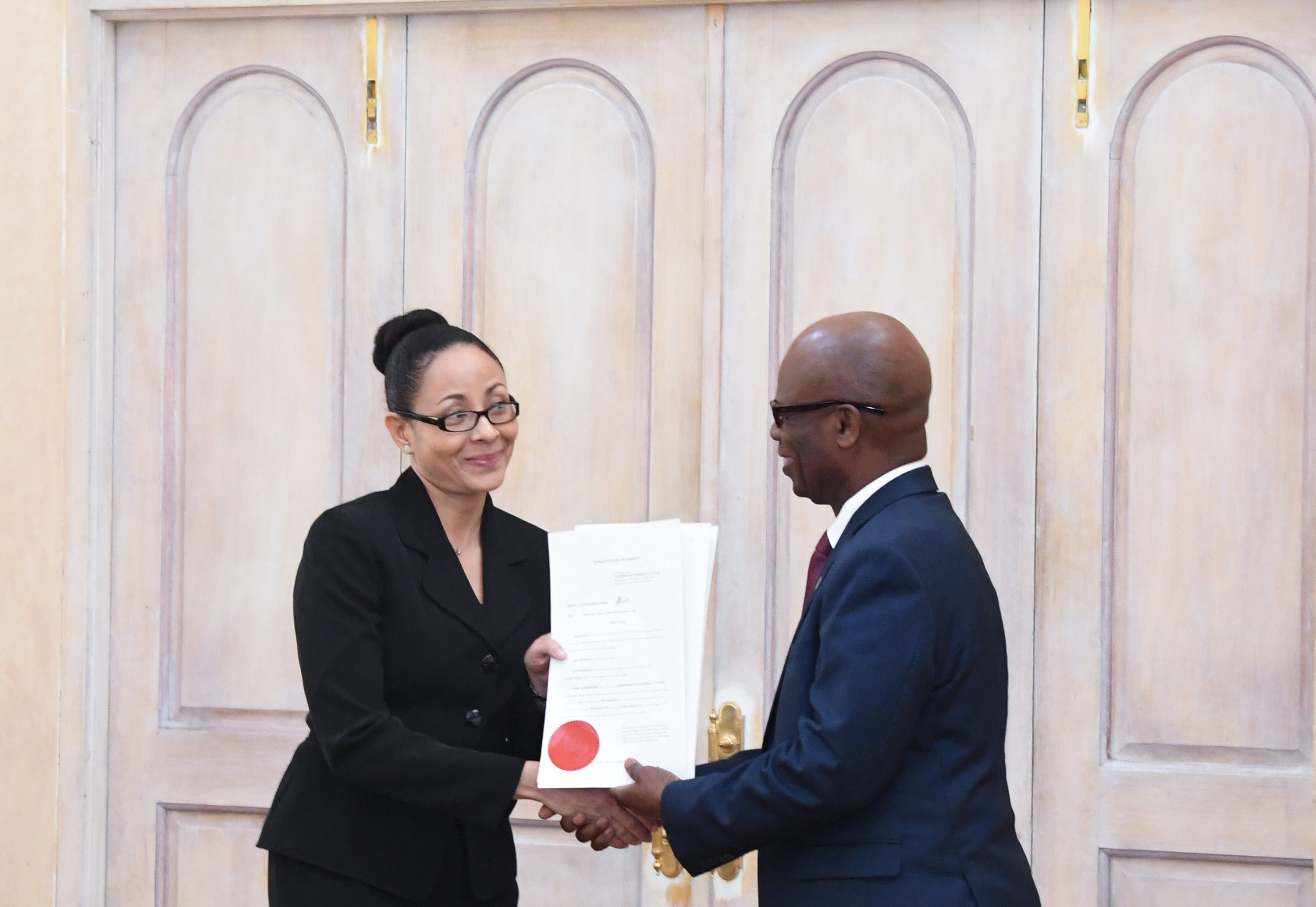 Deputy Governor-General the Honourable Steadman Fuller presents the Hon. Miss. Justice Carolyn N. Tie with her instrument of appointment. 