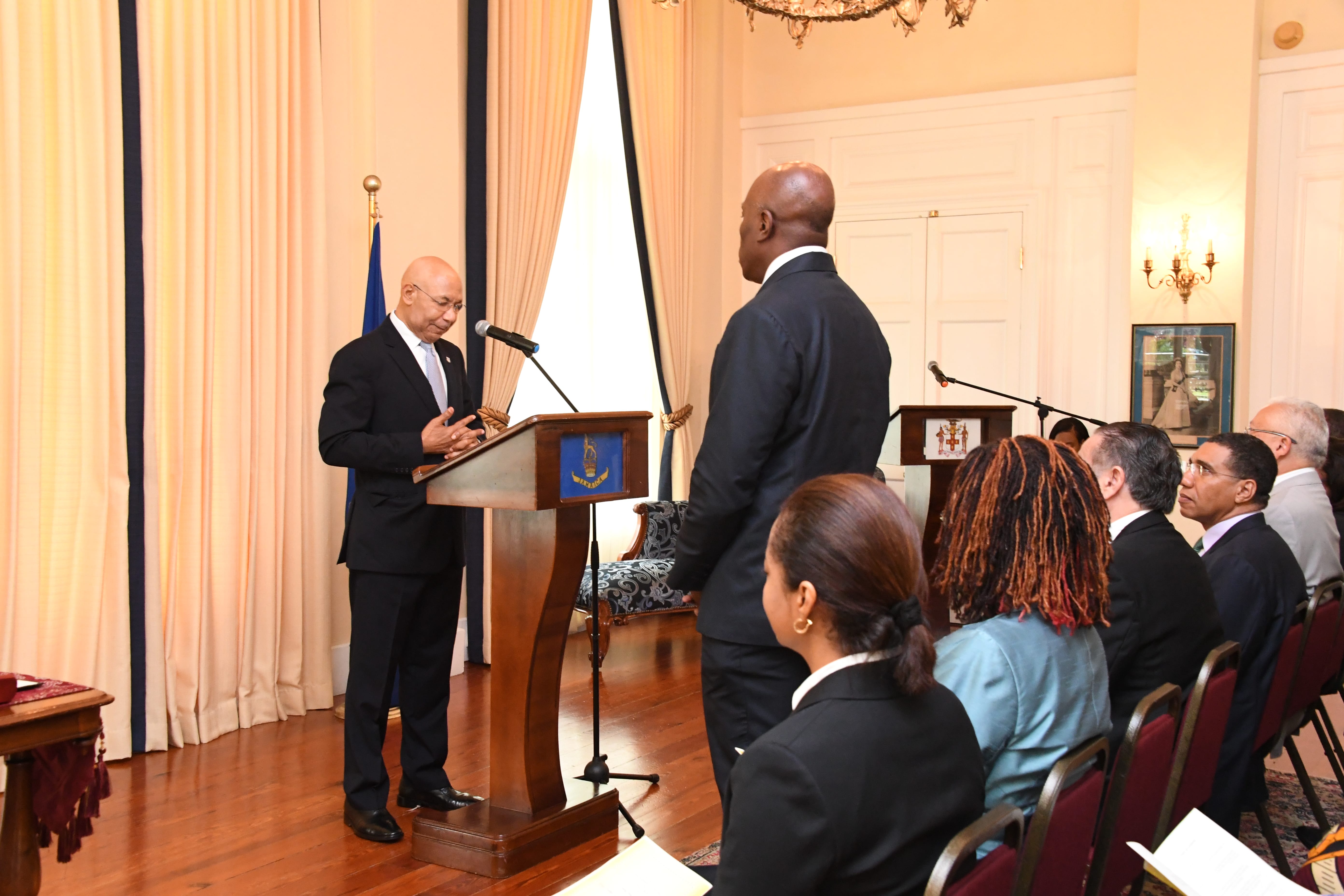 His Excellency The Governor-General reads the Instrument of Appointment for the Honourable Mr. Justice Bryan Sykes as Acting Chief Justice of Jamaica.